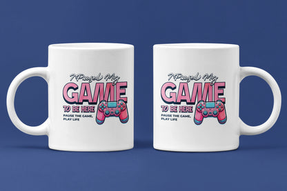 I Paused My Game To Be Here – Keramiktasse (325 ml) – 325 ml Keramiktasse als Doppel-Mockup, hochwertiges Gaming- & Nerd-Design Produktfoto.