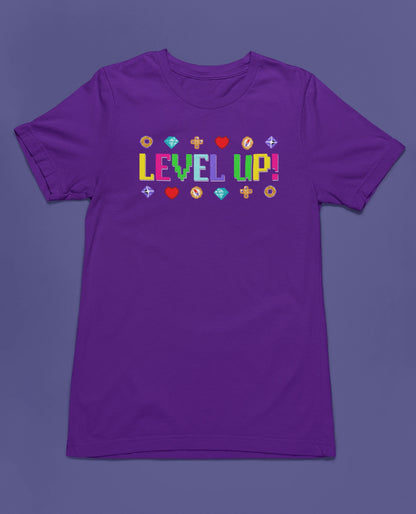 Level Up! | Buntes Retro Gamer T-Shirt im 8-Bit-Stil – lila T-Shirt als flatlay-Mockup, modernes Gaming-Design und hochwertiges Produktfoto.