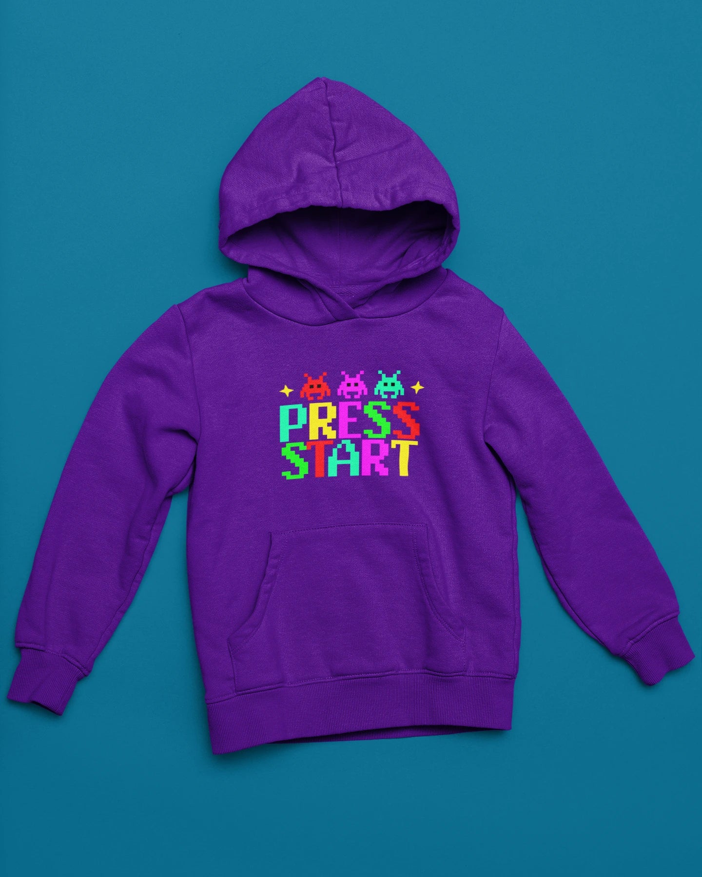 Press Start | Bunter Retro-Pixel Hoodie fuer Gamer – lila Hoodie als flatlay-Mockup, modernes Gaming-Design und hochwertiges Produktfoto.