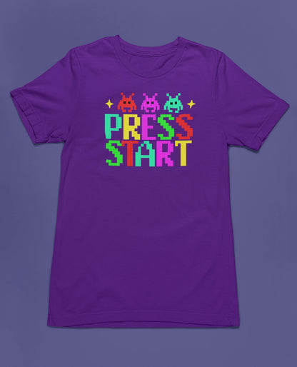 Press Start | Retro Gamer T-Shirt im bunten Pixel-Design – lila T-Shirt als flatlay-Mockup, modernes Gaming-Design und hochwertiges Produktfoto.